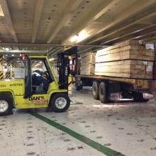 Unloading Lumber inside the decks of a car moving ship.